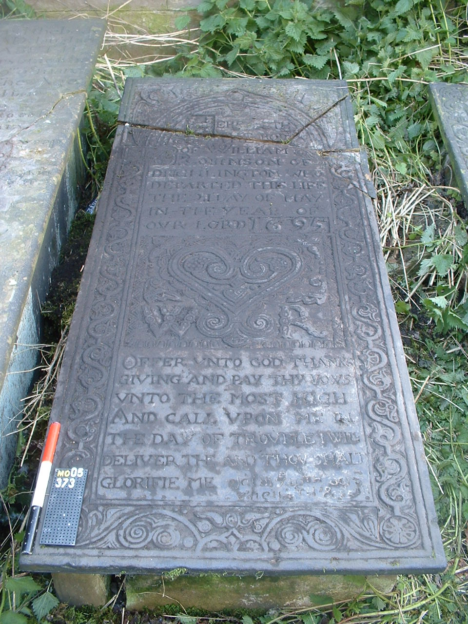 A tombstone with a heart motif